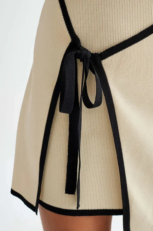 Robe courte beige sans manches bordures noires avec nœud